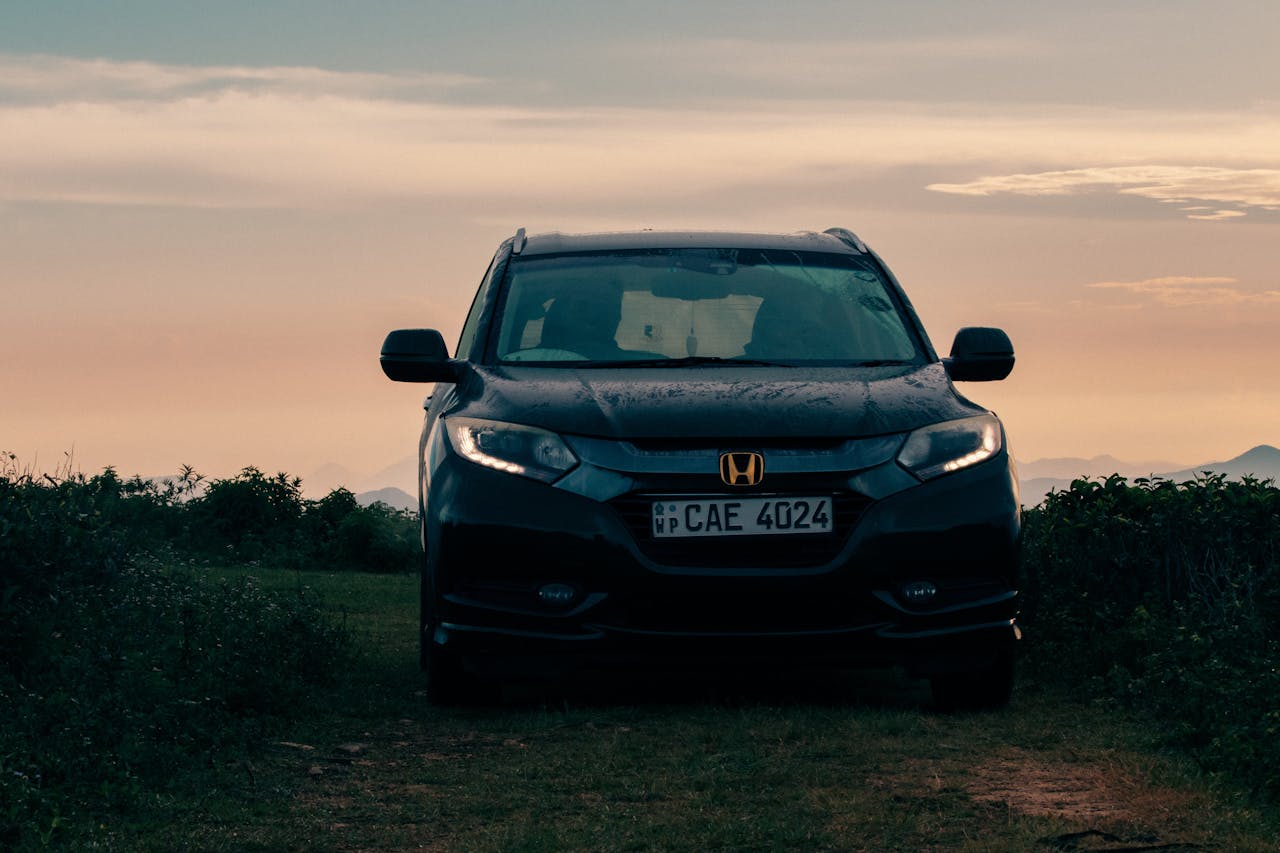 Front view of a Honda SUV in Madulsima, Sri Lanka, at sunset, capturing a serene rural backdrop.